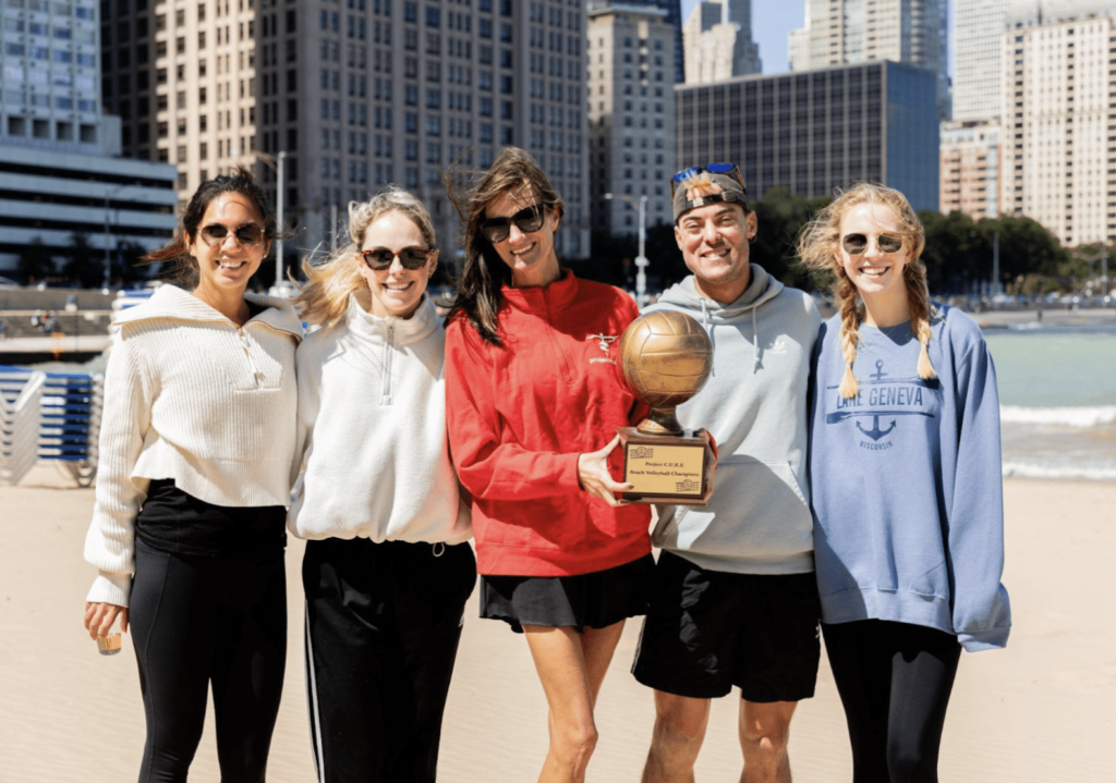 Image of project CURE beach volleyball team with trophy