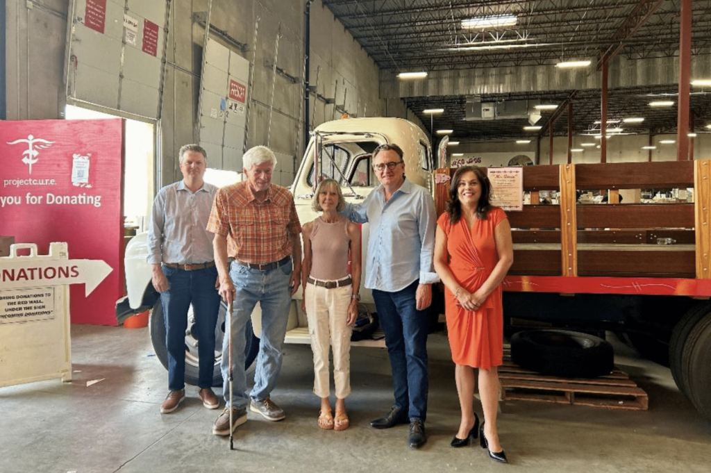 John Evans, Doug Jackson, and others pose at the Denver Project C.U.R.E. headquarters.