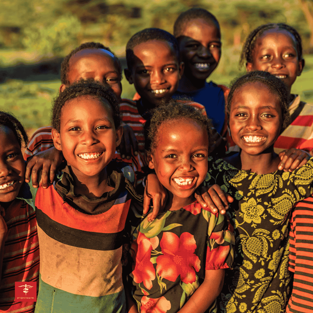 Children in Ethiopia's Oromia region smiling, part of medical relief in Ethiopia efforts by Project C.U.R.E.