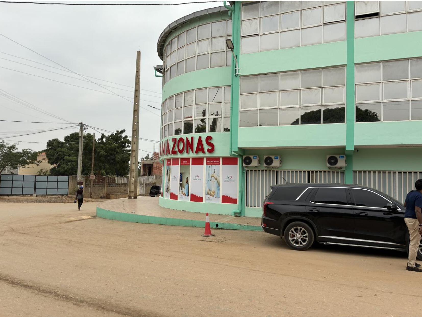 Exterior of Hospital Materno Infantil Amazonas in Luanda, Angola, a three-story mint green building with a red Amazonas sign.